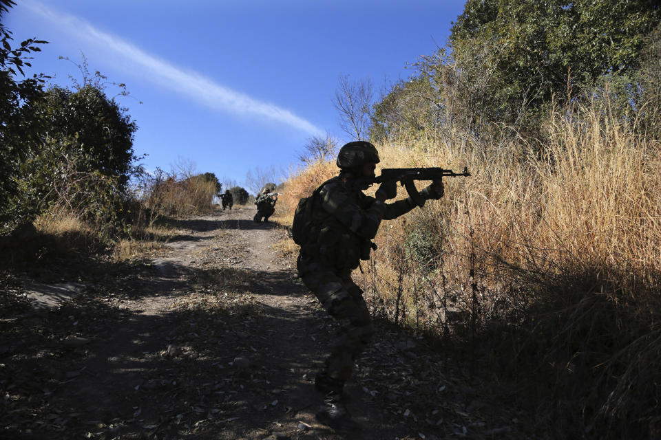 Indian army soldiers display their way of patrolling along the Line of Control, that divides the region between India and Pakistan, during a media trip to their area in Balakot in Poonch, about 250 kilometers (156 miles) from Jammu, India, Friday, Dec. 18, 2020. AP journalists were recently allowed to cover Indian army counterinsurgency drills in Poonch and Rajouri districts along the Line of Control. The training focused on tactical exercises, battle drills, firing practice, counterinsurgency operations and acclimatization of soldiers to the harsh weather conditions. (AP Photo/Channi Anand)