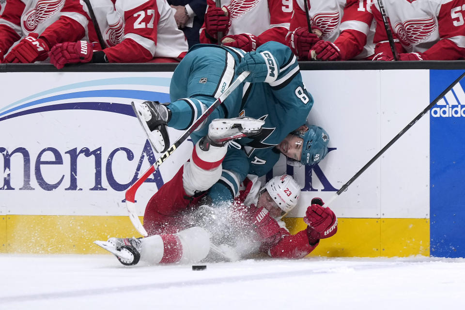 San Jose Sharks center Tomas Hertl (48) collides with Detroit Red Wings left wing Lucas Raymond (23) during the first period of an NHL hockey game Tuesday, Jan. 2, 2024, in San Jose, Calif. (AP Photo/Tony Avelar)