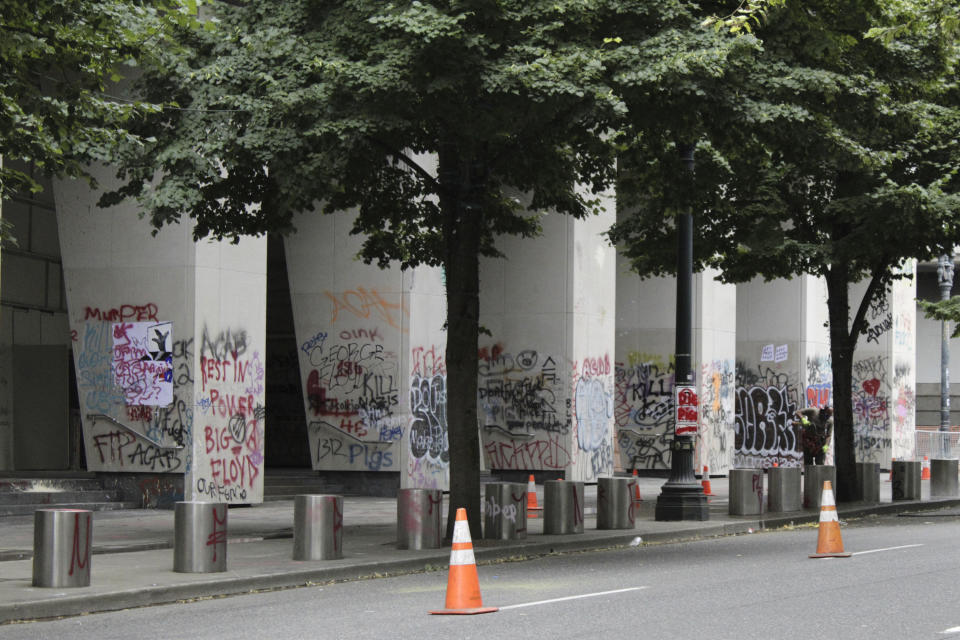 Graffiti from recent demonstrations covers pillars outside of the Mark O. Hatfield Federal Courthouse in downtown Portland, Ore., on Wednesday, July 8, 2020. Protesters who have clashed with authorities in Portland, Ore., are facing off not just against city police but a contingent of federal agents who reflect a new priority for the Department of Homeland Security: preventing what President Donald Trump calls "violent mayhem." The agents clad in military-style uniforms include members of an elite Border Patrol tactical unit, and their deployment to protect federal buildings and monuments is a departure for an agency created to focus on threats from abroad. (AP Photo/Gillian Flaccus)