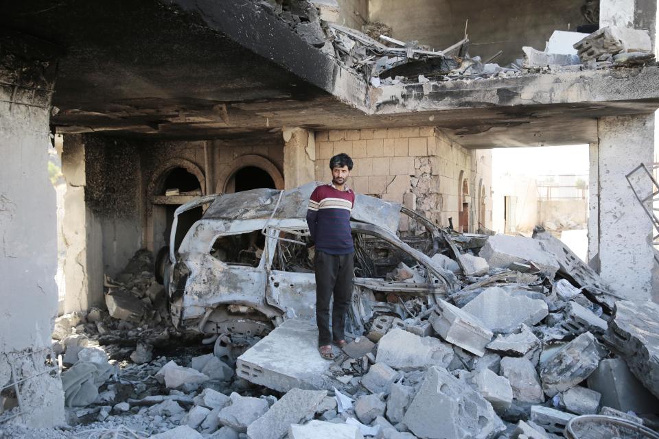 A Yemeni man stands on the rubble to inspect a damaged building at the site of a Saudi-led air strike in Sanaa in January.  (Hani Al-Ansi / Picture Alliance via Getty Images)