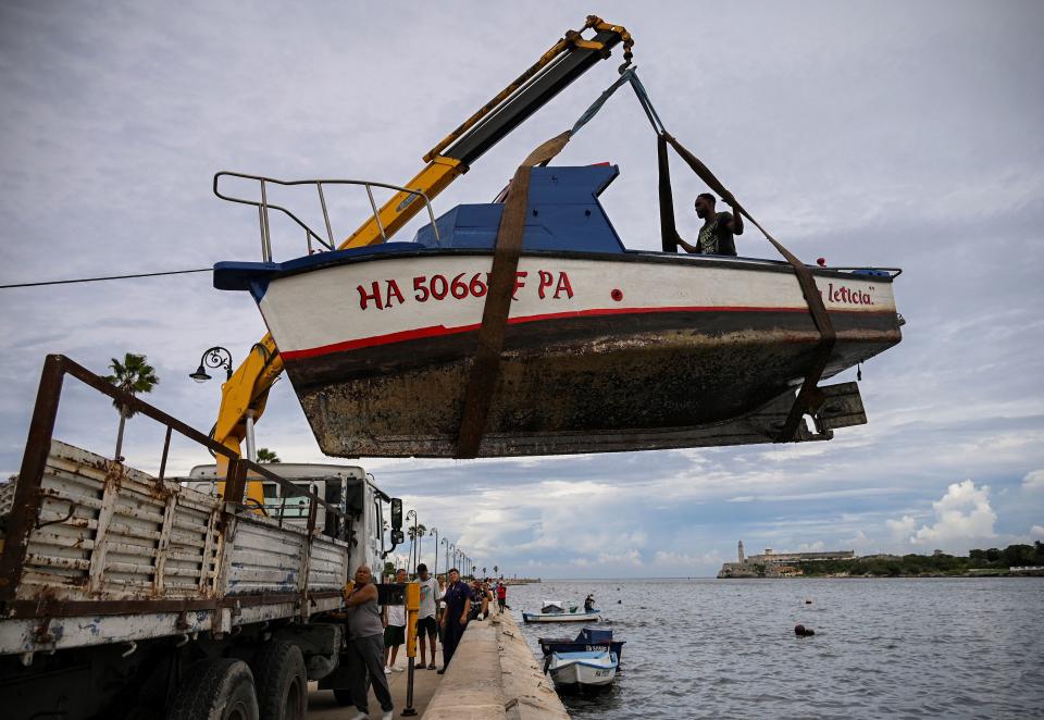 <p>Ya sea amarrando fuerte las embarcaciones o directamente quitándolas de la zona de peligro, en La Habana. (Photo by YAMIL LAGE/AFP via Getty Images)</p> 