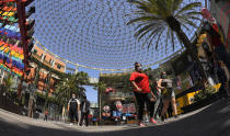 People walk through Universal CityWalk, Thursday, June 11, 2020, near Universal City, Calif. The tourist attraction, which had been closed due to the coronavirus outbreak recently re-opened. The Universal Studios tour is still closed. (AP Photo/Mark J. Terrill)