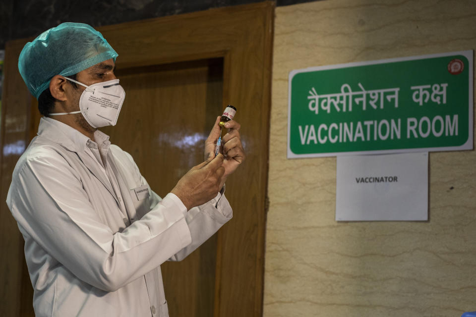 FILE - In this Jan. 8, 2021, file photo, a health worker performs a trial run of COVID-19 vaccine delivery system in New Delhi, India. The global death toll from COVID-19 has topped 2 million. (AP Photo/Altaf Qadri, File)