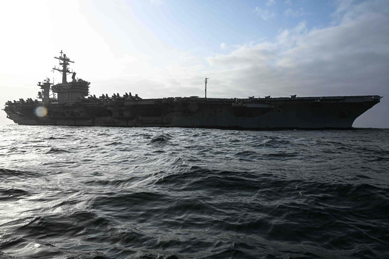 A US Navy aircraft carrier sailing the open ocean.