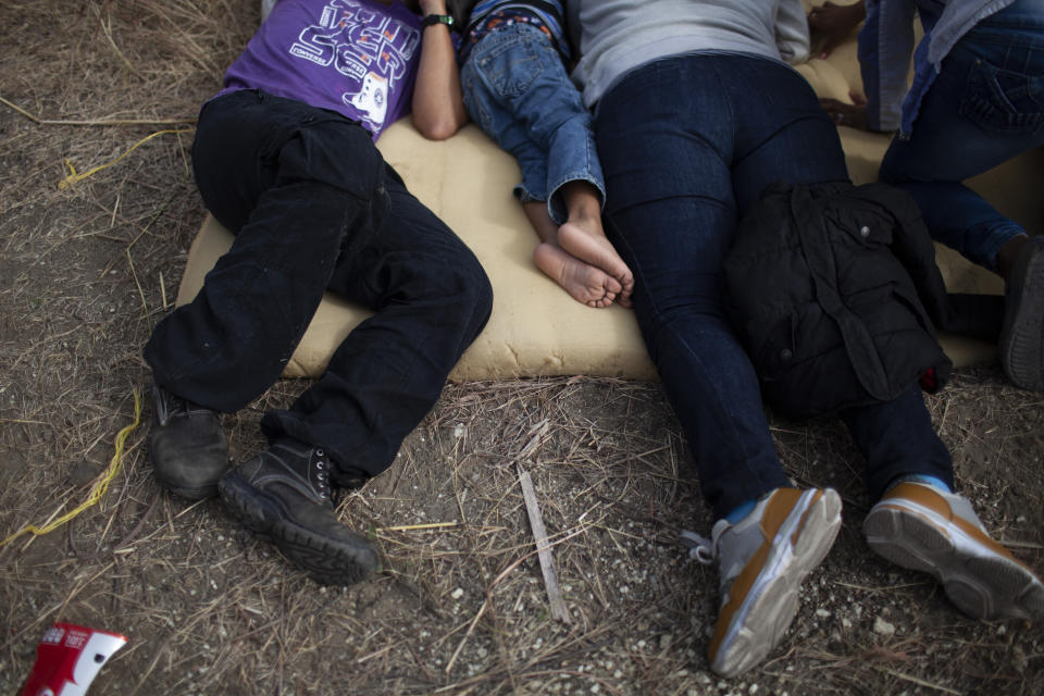 Honduran migrants rest on the side of the road near a police roadblock at a highway in Vado Hondo, Guatemala, Guatemala, Sunday, Jan. 17, 2021. Guatemalan police and soldiers have used tear gas and wielded batons and shields against a group of Honduran migrants that tried to push through their roadblock. (AP Photo/Sandra Sebastian)