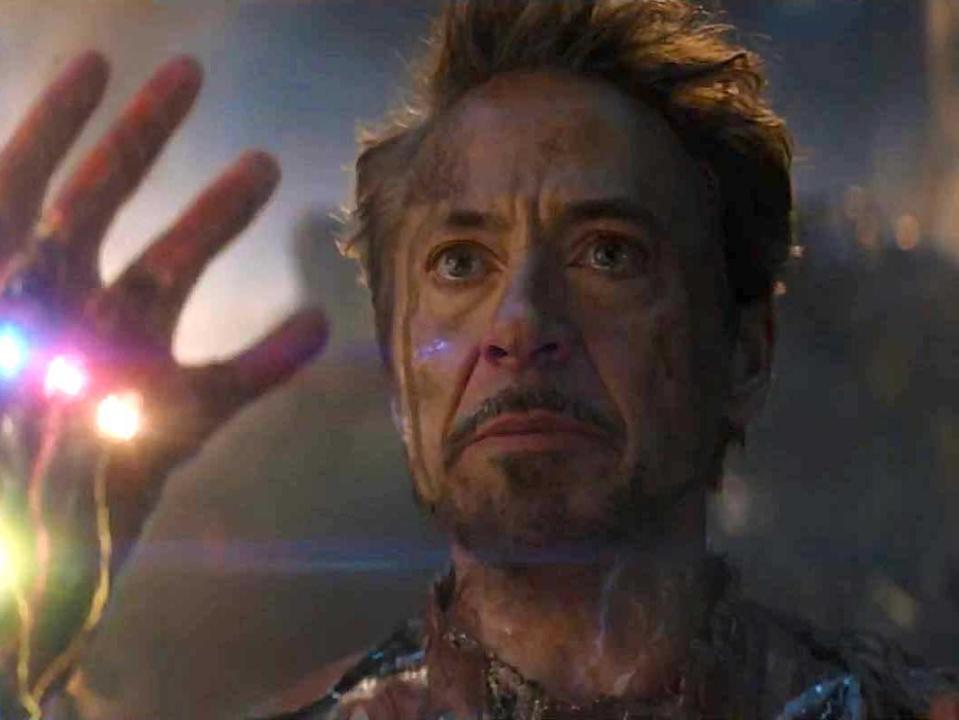 Robert Downey Jr. as Iron Man, holding up a gauntlet with six stones, in "Avengers: Endgame."