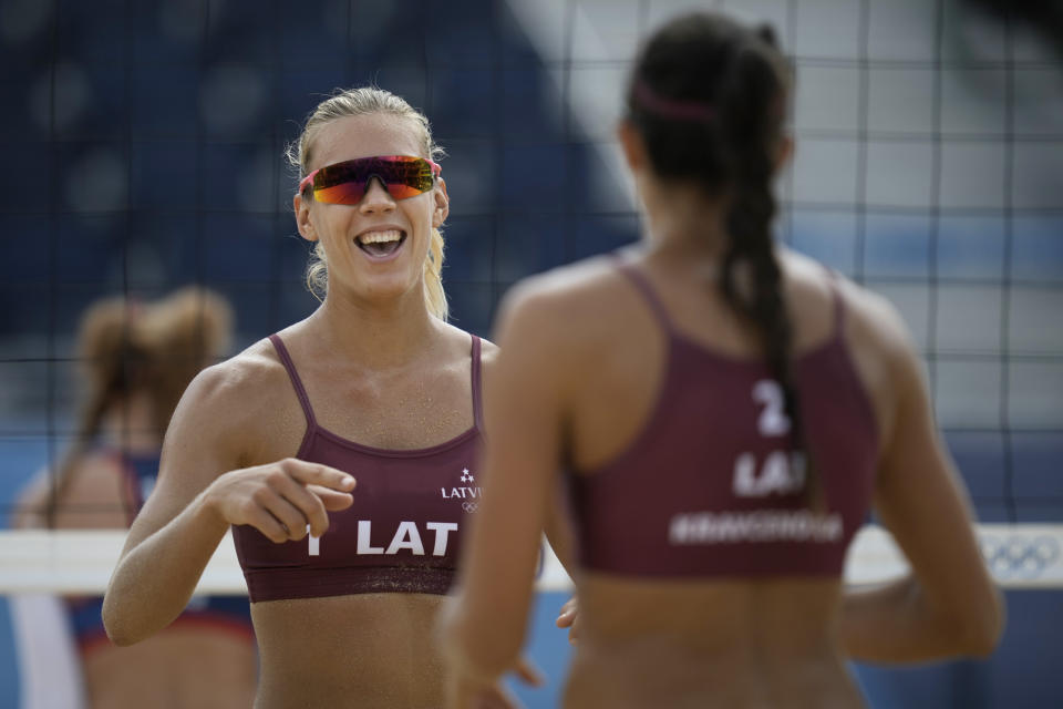 Tina Graudina, left, of Latvia, celebrates a point with teammate Anastasija Kravcenoka during a women's beach volleyball match against the United States at the 2020 Summer Olympics, Monday, July 26, 2021, in Tokyo, Japan. (AP Photo/Felipe Dana)