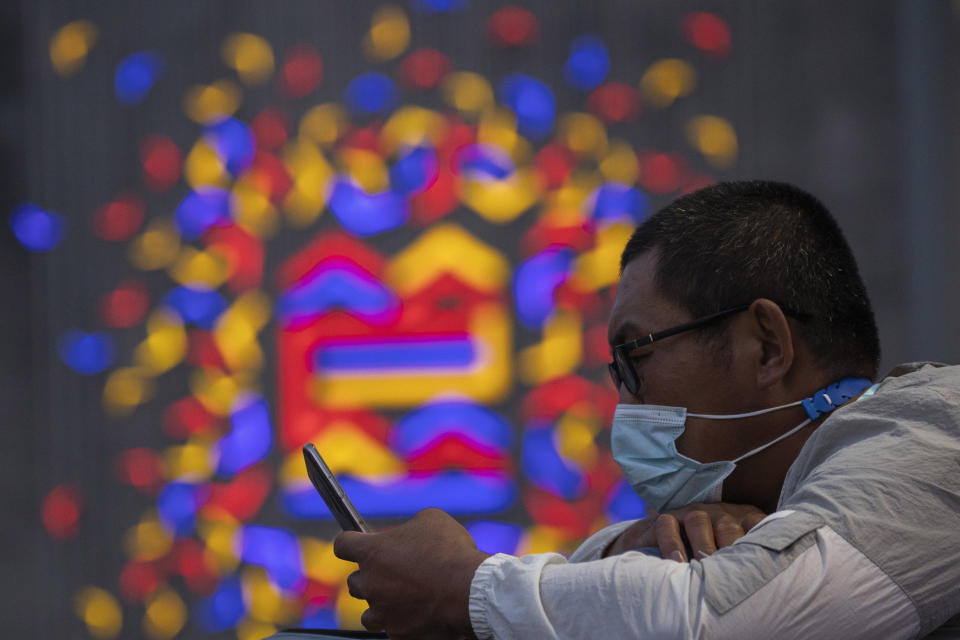 A delivery man wearing a mask to curb the spread of the coronavirus waits for orders along the restaurant street in Beijing on Friday, June 26, 2020. Even as Beijing appears to have contained the latest outbreak, businesses are still reeling from the prolonged impact of the coronavirus on the economy. (AP Photo/Ng Han Guan)