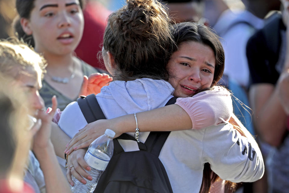 Students released from a lockdown embrace following a shooting at Marjory Stoneman Douglas High School in Parkland, Fla., Wednesday, Feb. 14, 2018. (John McCall/South Florida Sun-Sentinel via AP)