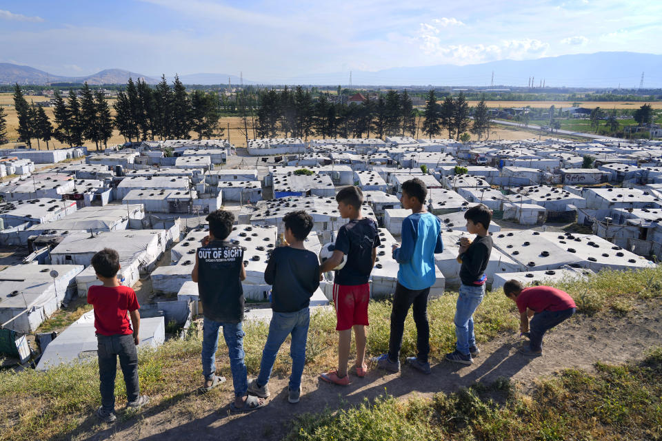 Syrian children stand on a hill above a refugee camp in the town of Bar Elias, in Lebanon's Bekaa Valley, Tuesday, June 13, 2023. Aid agencies are yet again struggling to draw the world's attention back to Syria in a two-day donor conference hosted by the European Union in Brussels for humanitarian aid to Syrians that begins Wednesday. Funding from the conference also goes toward providing aid to some 5.7 million Syrian refugees living in neighboring countries, particularly Turkey, Lebanon and Jordan. (AP Photo/Bilal Hussein)