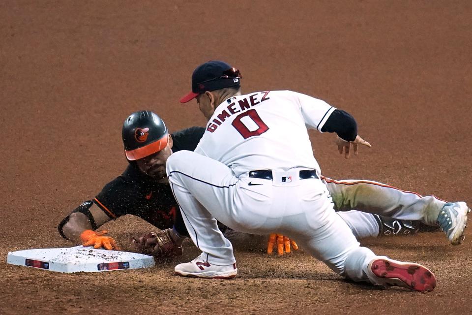 Baltimore Orioles' Anthony Santander, left, advances to second base under the tag of Cleveland Guardians second baseman Andrés Giménez (0) after hitting a single during the seventh inning of a baseball game Friday, Sept. 22, 2023, in Cleveland. (AP Photo/Sue Ogrocki)
