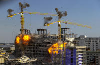 Two large cranes from the Hard Rock Hotel construction collapse come crashing down after being detonated for implosion in New Orleans, Sunday, Oct. 20, 2019. Officials set off thundering explosions Sunday to topple two cranes looming precariously over a partially collapsed hotel in New Orleans, but most of one crane appeared to be left dangling atop the ruined building while the other crashed down. (David Grunfeld/The Advocate via AP)