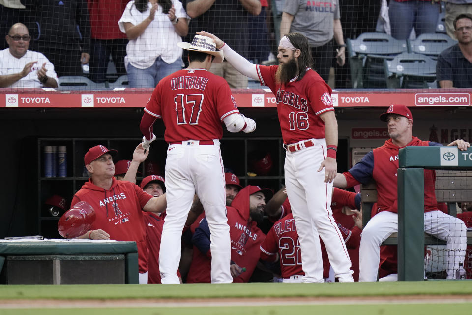 Los Angeles Angels' Brandon Marsh (16) puts a cowboy hat onto Shohei Ohtani while celebrating Ohtani's three-run home run during the third inning of the team's baseball game against the Texas Rangers on Saturday, July 30, 2022, in Anaheim, Calif. (AP Photo/Jae C. Hong)