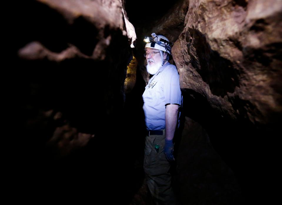 Adventure Cave Tours owner Bruce Herschend shimmies through a narrow section of cave on Thursday, Aug. 18, 2022. 