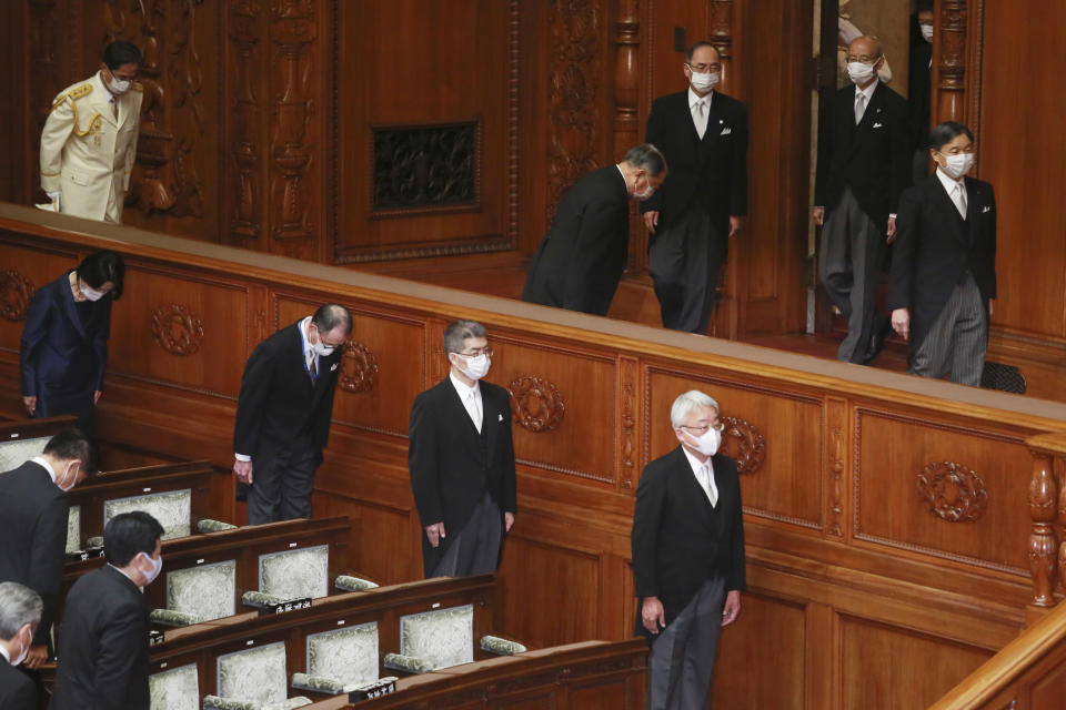 Japan's Emperor Naruhito, right, wearing a face mask to protect against the coronavirus arrives to read a statement to formally open an extraordinary Diet session at the upper house of parliament in Tokyo, Monday, Oct. 26, 2020. (AP Photo/Koji Sasahara)