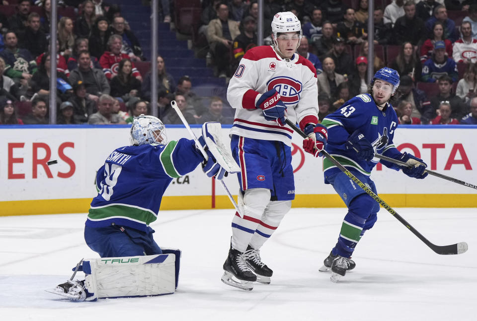 Montreal Canadiens' Juraj Slafkovsky, center, redirects the puck past Vancouver Canucks goalie Casey DeSmith, left, for a goal as Quinn Hughes watches during the second period of an NHL hockey game Thursday, March 21, 2024, in Vancouver, British Columbia. (Darryl Dyck/The Canadian Press via AP)