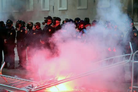 A burning flambeau is pictured in front of a police formation during an anti-government protest in front of Prime Minister Edi Rama's office in Tirana, Albania, May 11, 2019. REUTERS/Stringer