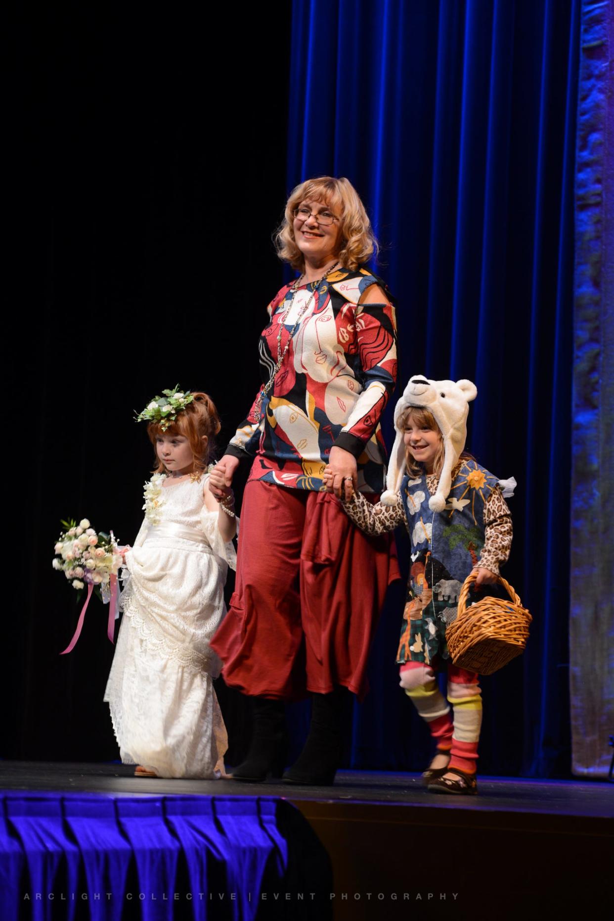 Tatyana Kuzmina wears an outfit made for the ReFashion category in 2017's Trashion ReFashion Runway Show from a dress with a Picasso pattern. Her granddaughter, Valeria, wears a dress made from two skirts that Kuxmina used in past shows. Her other model, Hannah, right, wears a look inspired and made from an adult vest with animal applique.