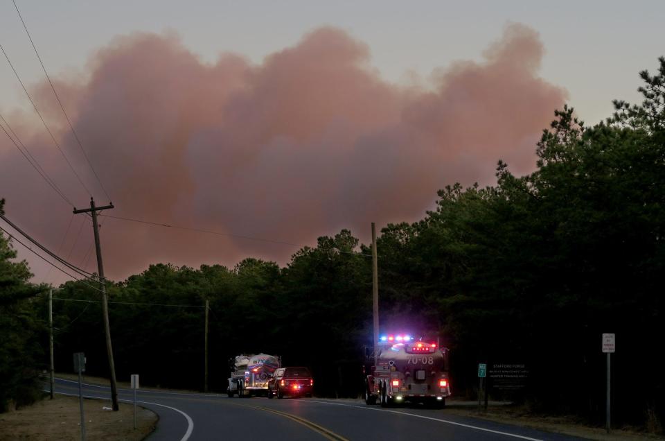 Tankers stand by along Route 539 as smoke rises above the Stafford Forge Wildlife Management area in Little Egg Harbor Tuesday afternoon, March 7, 2023.