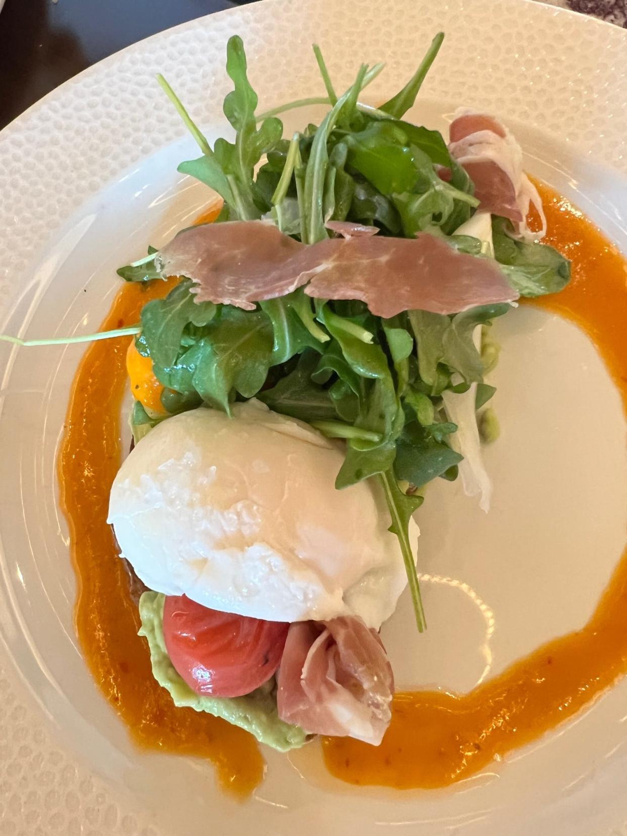 A poached egg, prosciutto, tomatoes and greens top avocado toast at Topolino's Terrace.