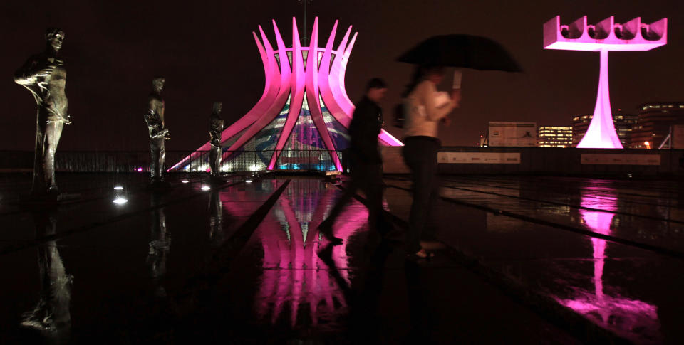 People walk in front of the Metropolitan Cathedral in Brasilia, Brazil, on Oct. 5, 2011. The cathedral is lit in pink to mark Breast Cancer Awareness Month.