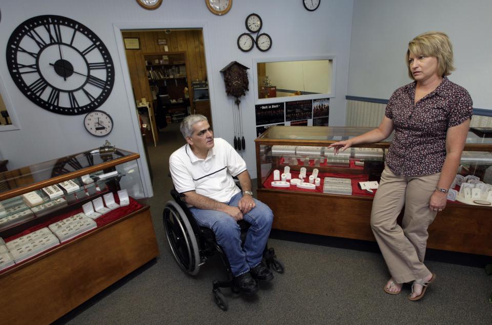 In this Thursday, June 14, 2012 photo, Mike Lamm talks with his wife Tracey in the showroom of his jewelry shop in Mediapolis, Iowa. These days, people aren’t buying much jewelry. What saves him is his ability to repair watches and make rings. There’s still enough call for that kind of work in the small town in rural southeastern Iowa. When the government reported that the Great Recession claimed nearly 40 percent of Americans' wealth, the figure alarmed economists. But for families across the country, the numbers merely confirm that they are not alone. (AP Photo/Charlie Neibergall)