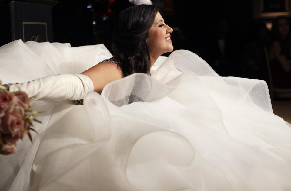 In this Thursday, Dec. 29, 2016 photo, Cathlyn Jones, of Austin, Texas, sinks into her billowing gown as she performs the "Texas Dip" curtsy at the International Debutante Ball in New York. (AP Photo/Mark Lennihan)