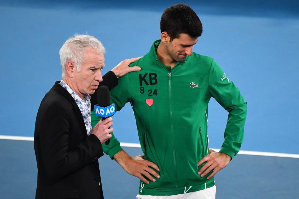 Commentator and former U.S. tennis star John McEnroe comforts Serbia's Novak Djokovic as he gets emotional while talking about Kobe Bryant after winning the men's singles quarter-final match against Canada's Milos Raonic on Day 9 of the Australian Open in Melbourne on Jan. 28, 2020. / Credit: WILLIAM WEST/AFP via Getty Images