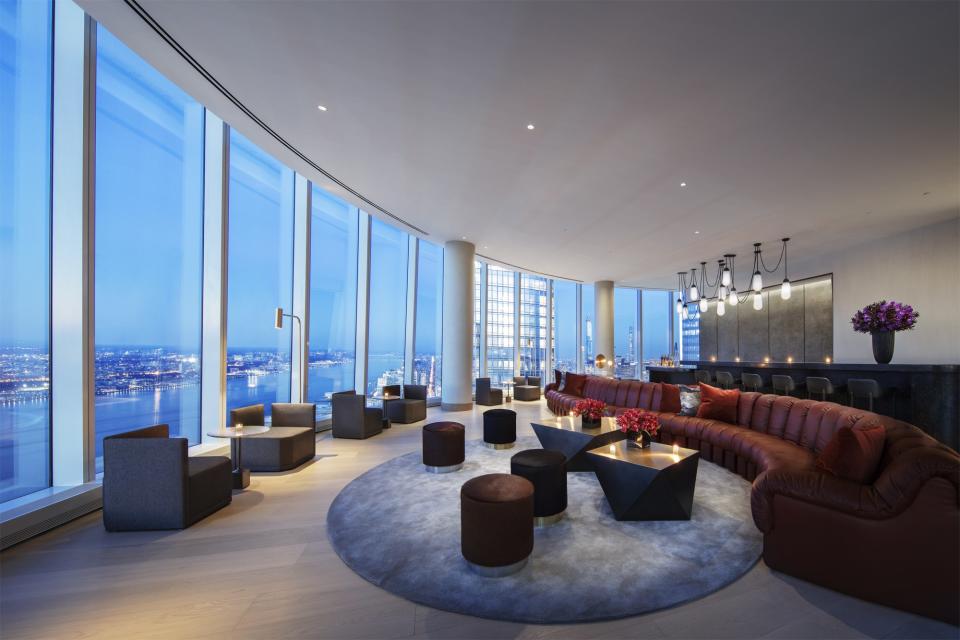 The lounge features a De Sede snake sofa with a rug from Sacco Carpet and cocktail tables by Tom Faulkner. Custom pendants by Apparatus hang above. Rockwell Group designed these interior spaces with flexibility in mind.