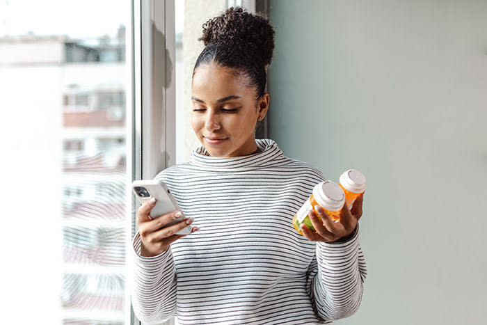 mujer con un bote de suplementos