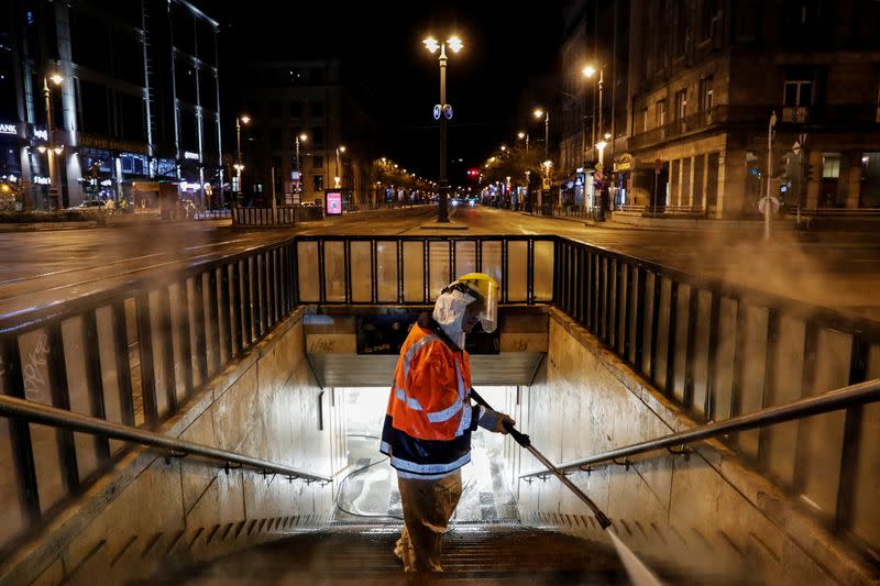 A worker wearing protective suit cleans and disinfects a flight of stairs of an underpass to prevent the spread of coronavirus disease (COVID-19), in downtown Budapest