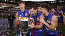 Josh Dunkley, Luke Dahlhaus and Tom Liberatore of the Bulldogs celebrates with the trophy. Pic: Getty