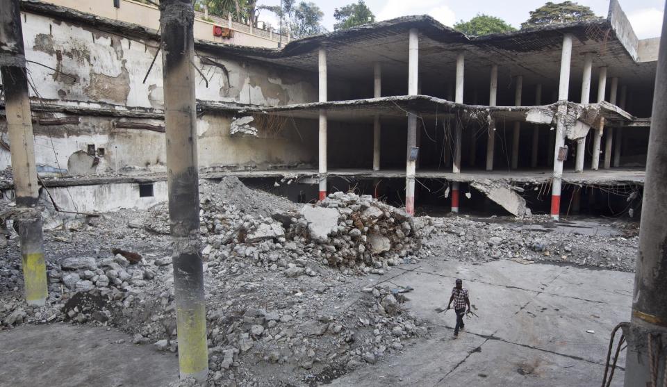 Workers continue the long process of removing rubble from the damaged Westgate Mall in Nairobi, Kenya Tuesday, Jan. 21, 2014. Court officials and four handcuffed ethnic Somalis accused of aiding the gunmen who attacked Nairobi's Westgate Mall in Sept. 2013, walked through the heavily damaged shopping center on Tuesday led by Chief Magistrate Daniel Ochenja, to help the court visualize the mall's layout for the ongoing trial of the four men. (AP Photo/Ben Curtis)