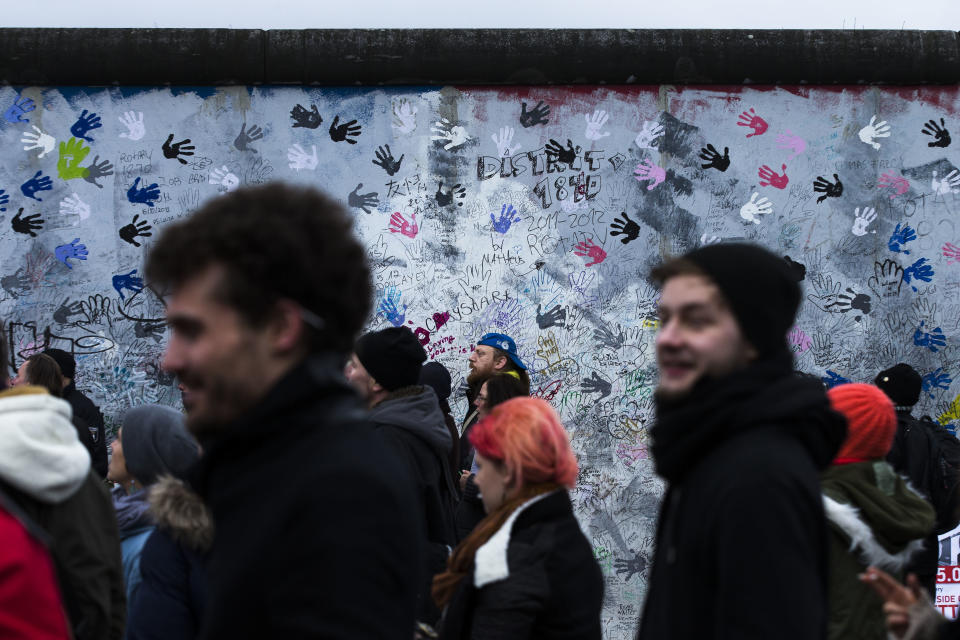 Protestors are gathering in front of a part of the former Berlin Wall in Berlin, Germany, Friday, March 1, 2013. Construction crews stopped work Friday on removing a small section from one of the few remaining stretches of the Berlin Wall to make way for a condo project after hundreds of protesters blocked their path.(AP Photo/Markus Schreiber)