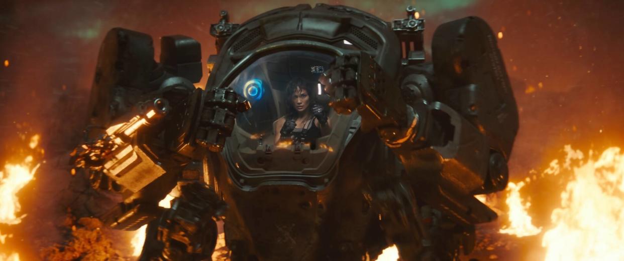  A woman inside an armored robot with flames surrounding her. 