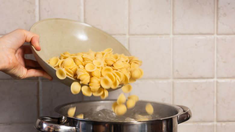 pasta going into pot of boiling water