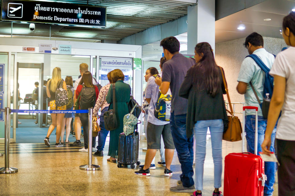 Many people are waiting in line Holding luggage and suitcases security screening