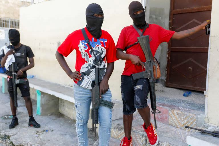 Miembros enmascarados de la pandilla “G9 y Familia” montan guardia durante una conferencia de prensa de su líder, conocido como “Barbecue”, en Puerto Príncipe, el 5 de marzo de 2024. (Foto AP /Odelyn Joseph)