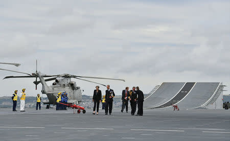 Britain's Prime Minister Theresa May talks with Commodore Jerry Kyd, Captain of the British aircraft carrier HMS Queen Elizabeth, during her tour of the ship, after it arrived at Portsmouth Naval base, its new home port, in Portsmouth, Britain August 16, 2017. REUTERS/Ben Stansall