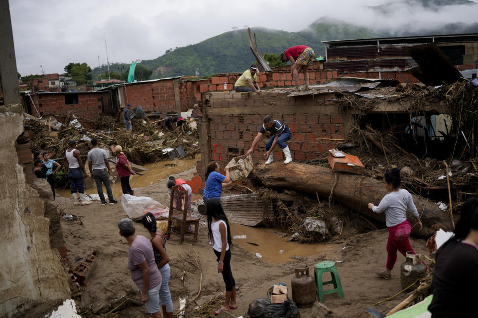 Local residents clean up homes damaged by floods in Las Tejerias, Venezuela, Sunday, Oct. 9, 2022, after days of heavy rain caused flash floods. (AP Photo/Matias Delacroix)