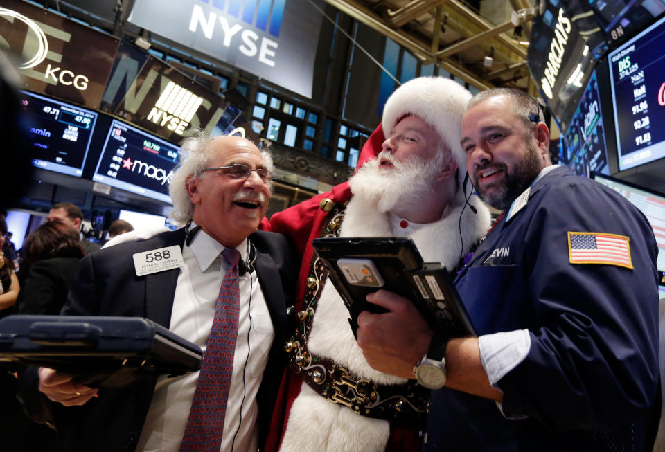 Traders pose with Santa on the floor of the New York Stock Exchange, Wednesday, Nov. 26, 2014. (AP Photo/Richard Drew)