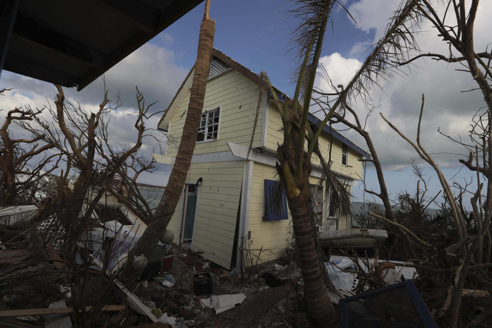 A home damaged by Hurricane Dorian is surrounded by debris in Eastern Shores just outside of Marsh Harbor, Abaco Island, Bahamas, Saturday, Sept. 7, 2019. The Bahamian health ministry said helicopters and boats are on the way to help people in affected areas, though officials warned of delays because of severe flooding and limited access. (AP Photo/Fernando Llano)