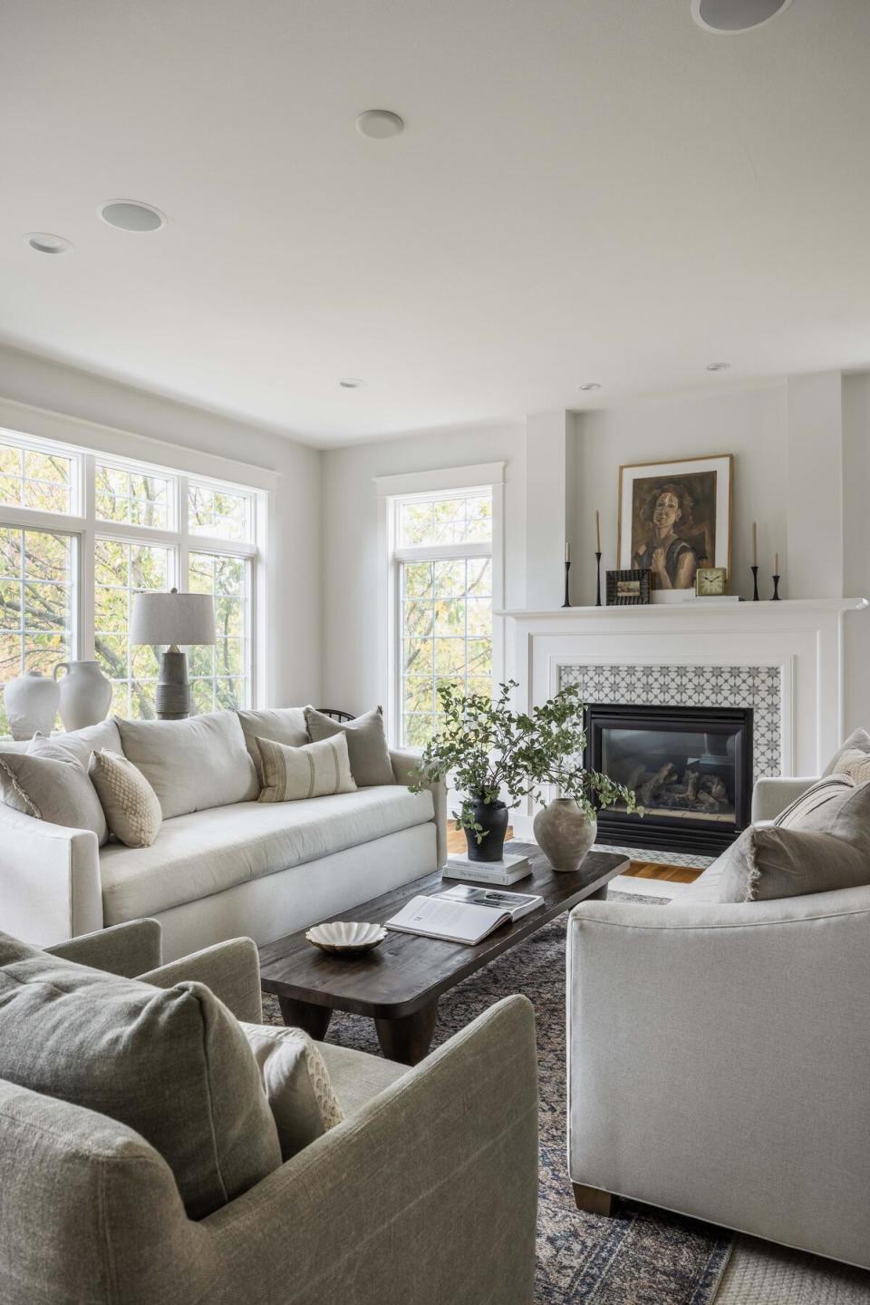 A muted, gray living room featuring a fireplace tiled with a geometric motif