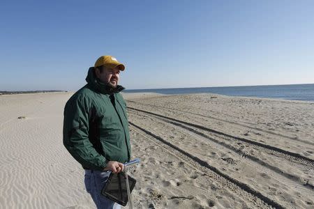 Sean Cornell, a field geologist who carries out research on and around Wallops Island, walks at the pristine beach on Assateague Island which has seen the effects of sea level rise in Virginia October 25, 2013. REUTERS/Kevin Lamarque