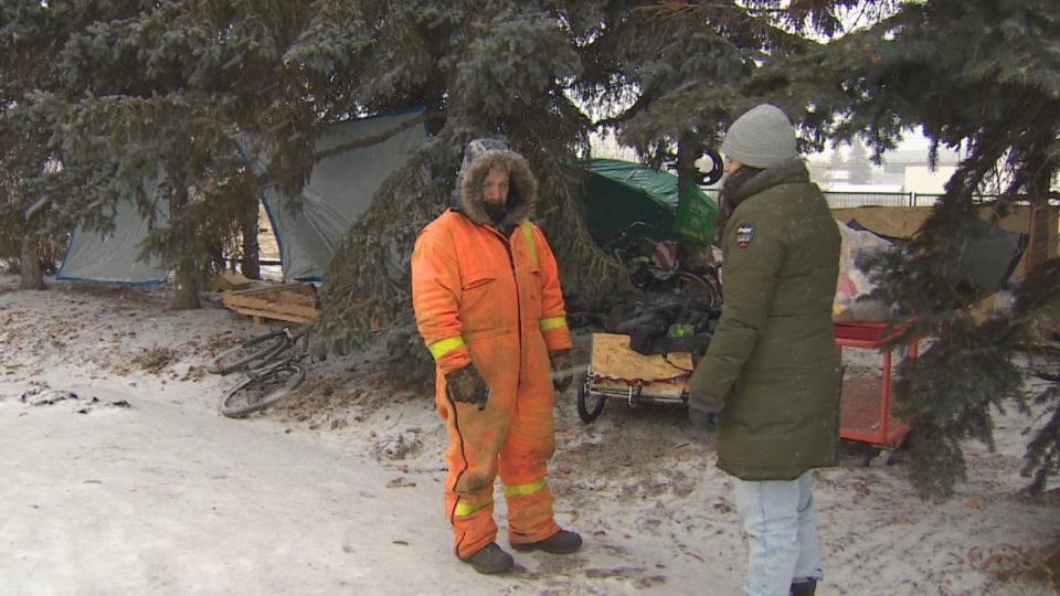 Anson Palmer speaks with reporter Paige Parsons at his friend's encampment along Gateway Boulevard on Jan. 9, 2023.