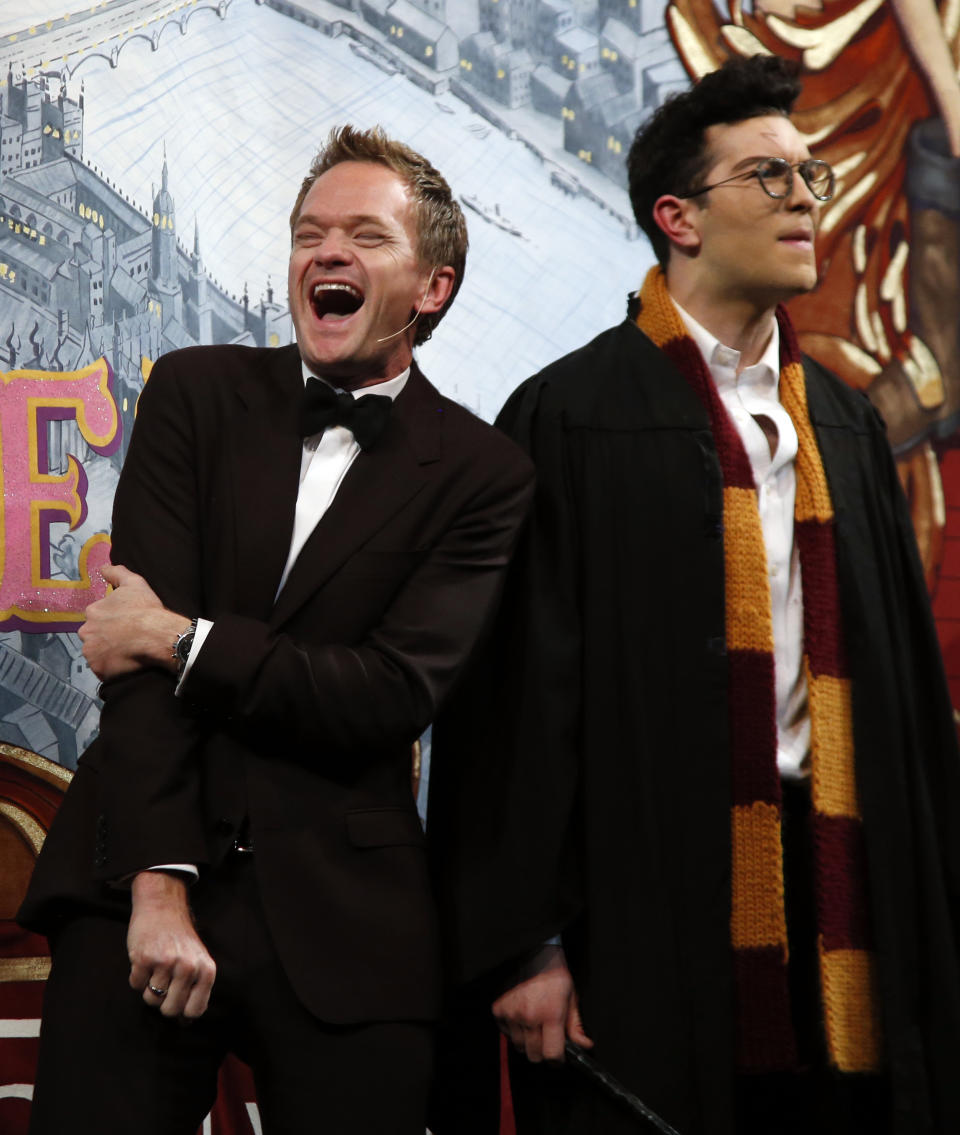 Actor Neil Patrick Harris, left, laughs onstage with actor Ethan Hardy as "Harry Potter" during his roast as Man of The Year by Harvard University's Hasty Pudding Theatricals in Cambridge, Mass., Friday, Feb. 7, 2014. (AP Photo/Elise Amendola)