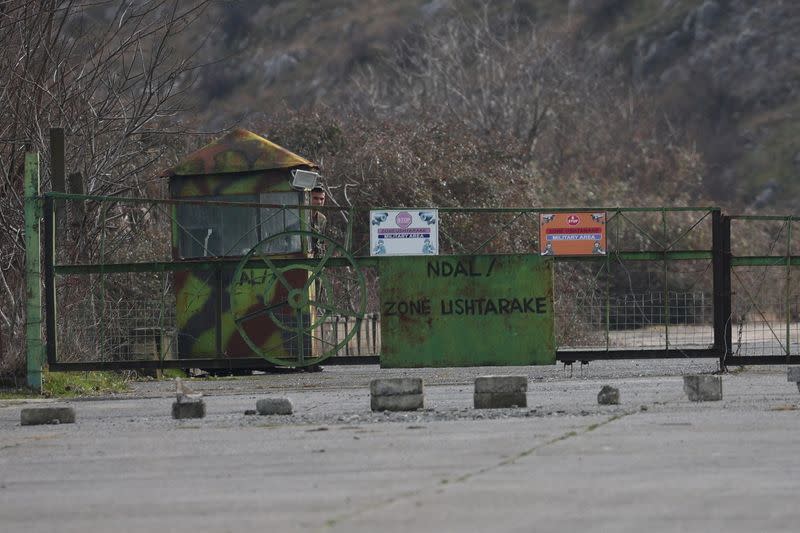 A soldier looks on at a checkpoint at a military base, in Gjader