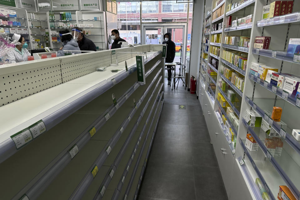 FILE - Empty shelves are seen in a pharmacy as customers tries to find medicine to prepare for a wave of COVID-19 outbreak in Beijing, Dec. 13, 2022. China's sudden reopening after two years holding to a "zero-COVID" strategy left older people vulnerable and hospitals and pharmacies unprepared during the season when the virus spreads most easily, leading to many avoidable deaths, The Associated Press has found. (AP Photo/Ng Han Guan, File)