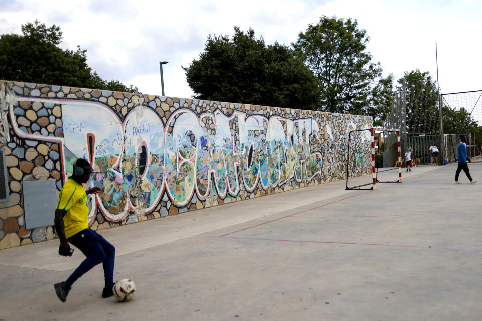 Un joven patea un balón en un una cancha en Mataro, España el viernes 12 de julio del 2024 en el vecindario de Rocafonda. (AP Foto/Joan Monfort)