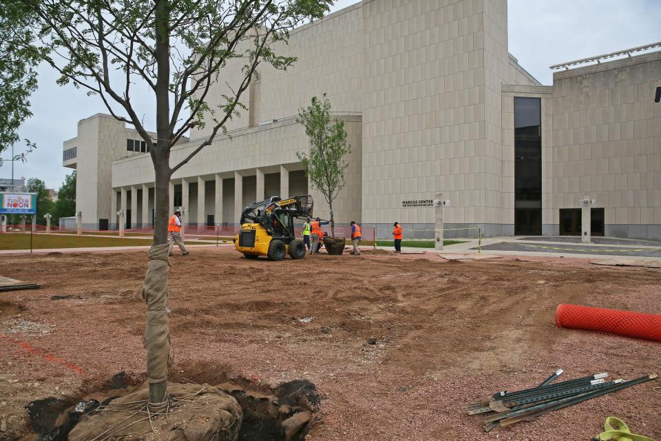 Work at the Marcus Center on Tuesday included trees being planted to help complete the replacement of a former sunken grove with an accessible, tree-lined lawn.